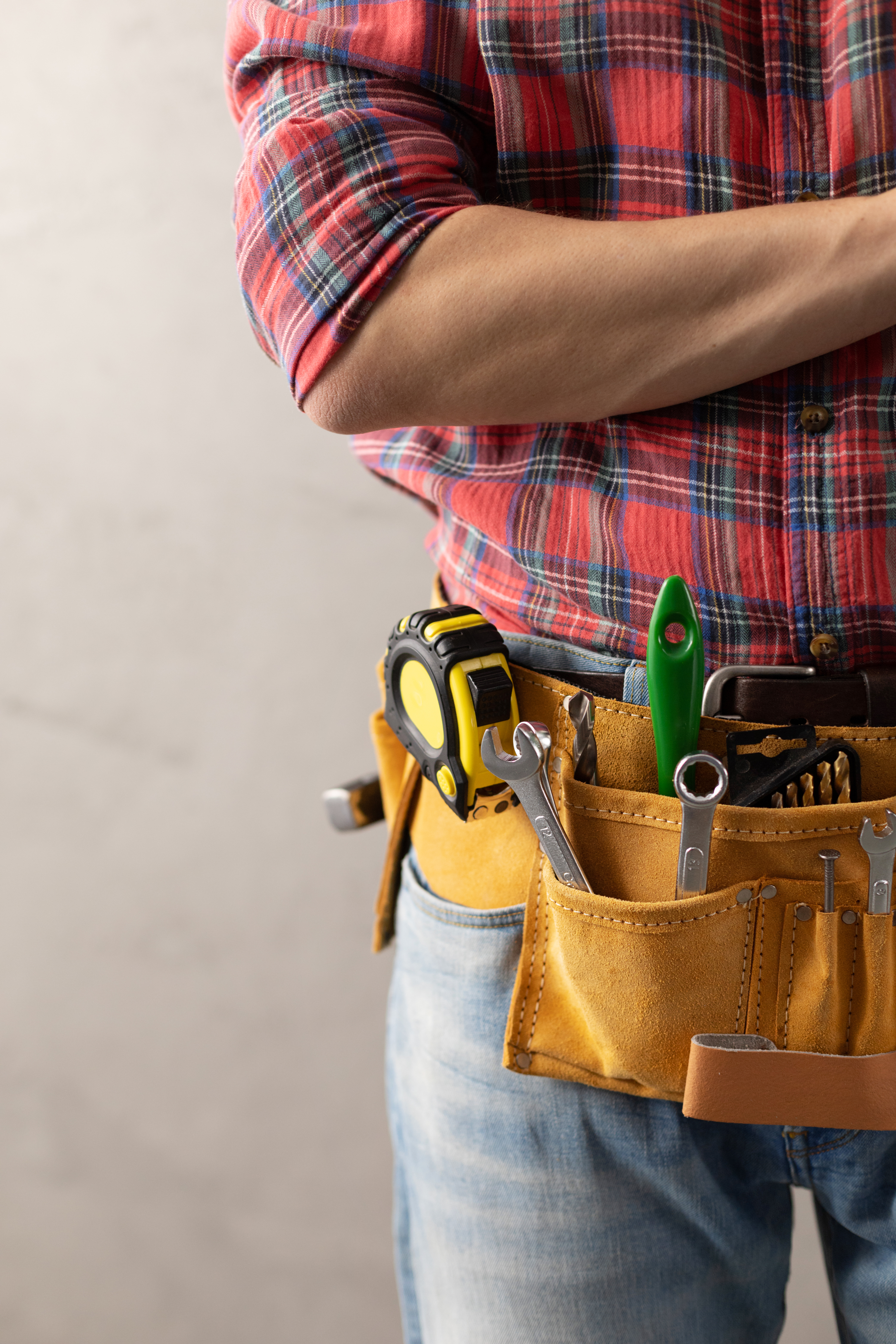 Man worker and tool belt near wall. Male hand and construction t